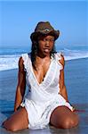 African-American woman in hat posing on beach