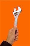 a hand holding a Wrench tool with a color background