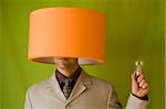 a businessman with a lamp in his head and holding the lamp