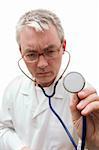 pensive doctor in glasses listening the stethoscope. Soft-focused, focal point is on face