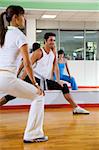 health club: man and women doing stretching and aerobics