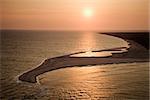 Aerial view of sun over Atlantic ocean and shoreline of Bald Head Island, North Carolina.