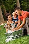 Caucasian family with toddler son giving  English Bulldog a bath outdoors.