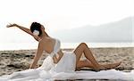 Woman in white clothes sitting on the beach