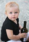 Baby boy holding a bottle of wine