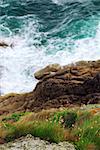 Looking down a cliff onto stormy ocean at the rocky coast of Brittany, France