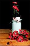 A chihuahua posing with some flowers.