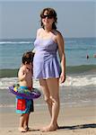 Pregnant woman with her son on the beach