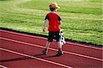 Boy with a checked flag walking on a racetrack