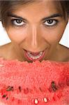 Beautiful young woman eating a slice of watermelon