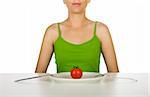 Woman in the kitchen with a tomato on the plate in front of her