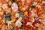 Boys Playing Throwing the Fall Leaves Up in the Air