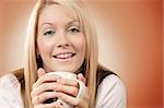 Happy and smiling female drinking coffee in an urban café.