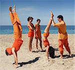 Family in orange clothes having fun on the beach
