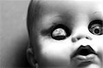 Close up of a scary doll with one eye closed and one eye open