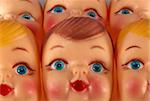 A close up of plastic doll faces ready for assembly into toys