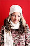 winter portrait of a beautiful young woman is freezing with a cap and a scarf