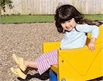 Little girl smiling and sliding on children's chute