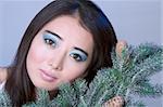 Asian girl by branches of Christmas tree