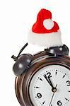Partial view of alarm clock with christmas hat, isolated over white background