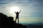 Trekker silhouette at the summit of his climb