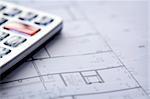 Calculator and house plan blueprints close up , shallow DOF photo