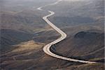 Aerial of Route 14 with traveling vehicles through rural California landscape, USA.