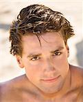 Head and shoulder portrait of handsome man on beach.