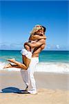 Couple in emotional embrace on Maui, Hawaii beach.