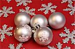 Silver christmas ornaments on red