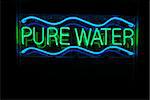 Iluminated pure water neon sign on black background