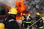 Firefighter at work on an abandoned house in flame