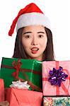 Excited Asian girl with pile of Christmas gifts