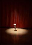 Illustration of an empty stool on a stage of a theater, concert or comedy show lighted by a single spotlight in front of a red curtain.