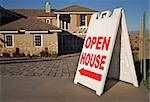 Open House Sign in Front of A Brand New Home. Room for your own message at the top of the sign.