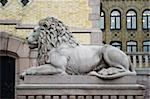 A lion statue sits majesticaly on it's pedestal.