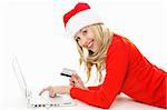 Shopping online is easy, convenient and secure.  Smiling female using a laptop and holding a credit card or other card to buy Christmas gifts, pay bills or  banking.  Data on back of  card has been replaced.