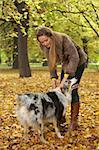 20-25 years old beautiful sexy woman playing with dog in natural autumn outdoors