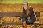 20-25 years old beautiful sexy woman portrait in natural autumn outdoors. Sitting on park bench