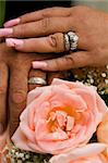 Newly Weds Holding Hands with Rings and Flowers