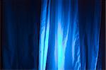 Blue Spot Lights Against Stage Curtain Background