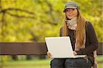 20-25 years old beautiful sexy woman portrait working on laptop computer in natural autumn outdoors