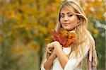 20-25 years old beautiful sexy woman portrait holding leafs in natural autumn outdoors