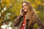 20-25 years old beautiful sexy woman portrait talking cell phone in natural autumn outdoors