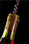 Opening a wine bottle with corkscrew, isolated on black