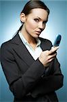 Beautiful and sexy brunette business woman isolated on clear background is using mobile phone.