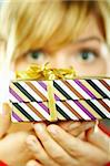 Beautiful young woman holding boxed gift
