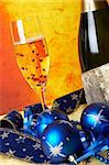 Christmas decoration with champagne bottle and full glass with stars, over colour background. Shallow DOF