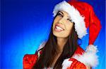 Portrait of beautiful brunette woman wearing sexy santa claus clothes on blue background