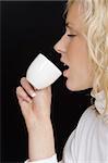Studio profile shot of a beautiful young blonde woman drinking tea/coffee